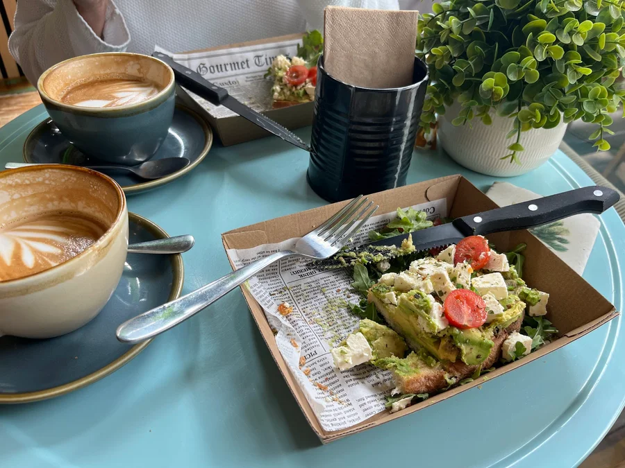 Breakfast and coffees on a turquoise table at the cafe